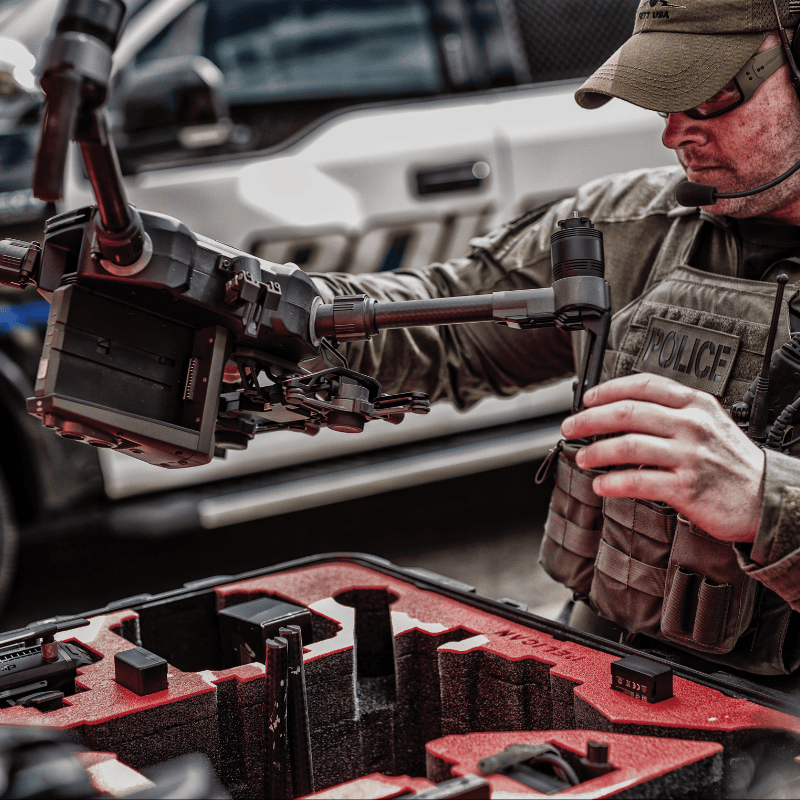 Law enforcement officer preparing a tactical surveillance drone for police operation, showcasing drone deployment in public safety and security missions.
