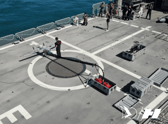 Tekever fixed-wing drone positioned on a catapult launch system aboard a naval vessel, with crew preparing for maritime UAV deployment.
